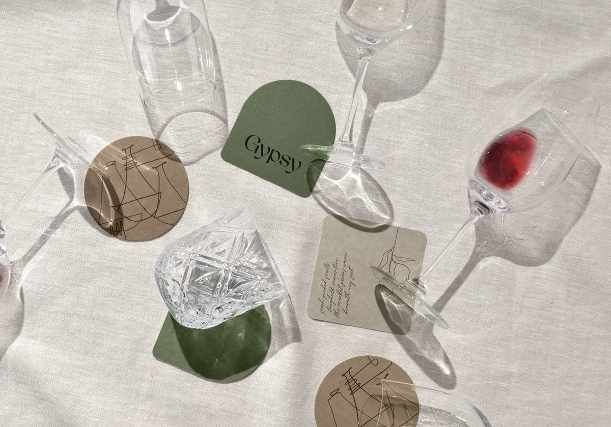 Gypsy: branded coasters among glassware on linen