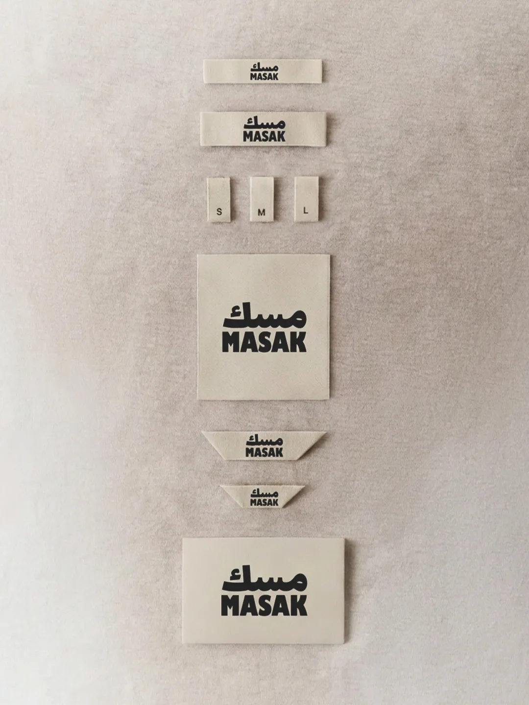 MASAK: the woven label sheet with its size tabs, the system laid out