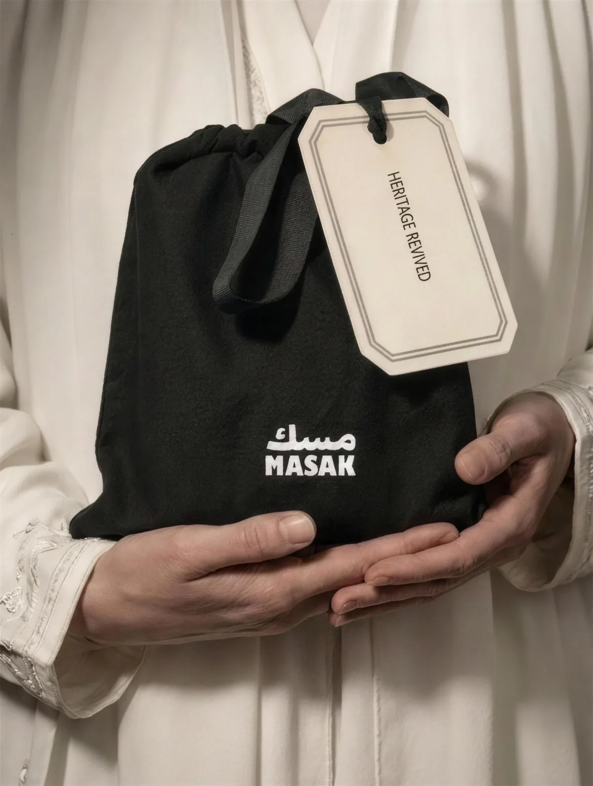 MASAK: the black bag held in two hands with the Heritage Revived tag
