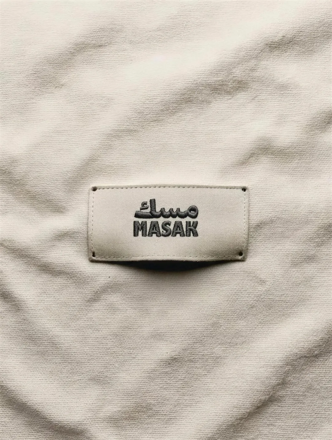 MASAK: the cream embroidered label stitched into raw cotton